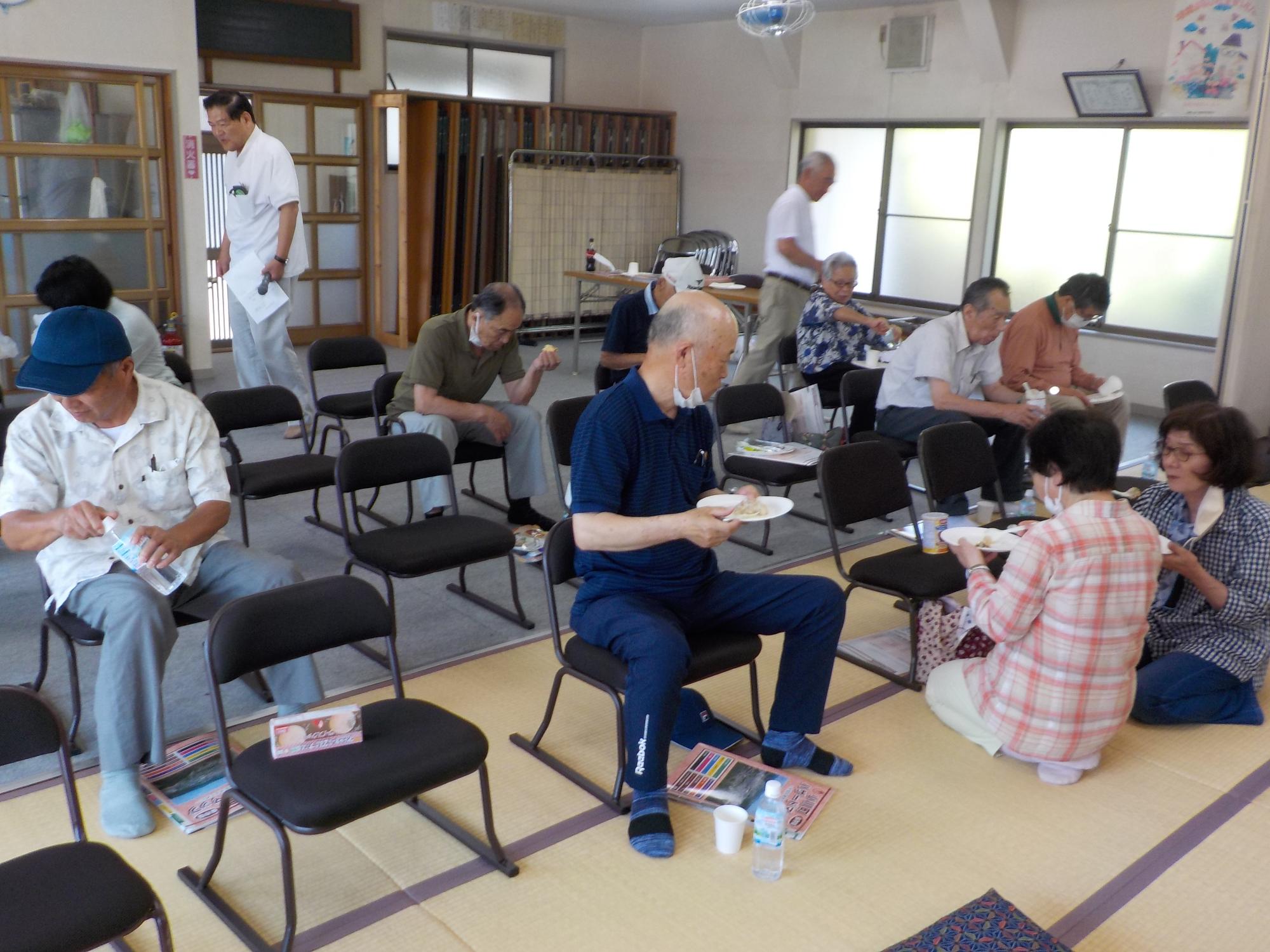 参加者の方々が試飲や試食をしている様子を前方から撮影した写真