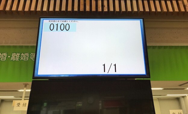 「交付窓口までお越しください。0100」と表示された交付呼出モニターの写真
