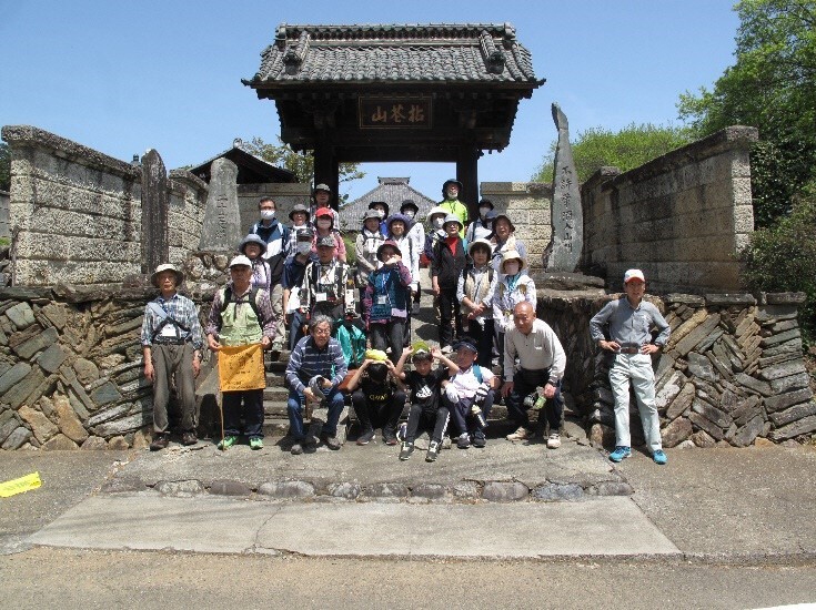 参加者たちが古い門の前に集合している写真