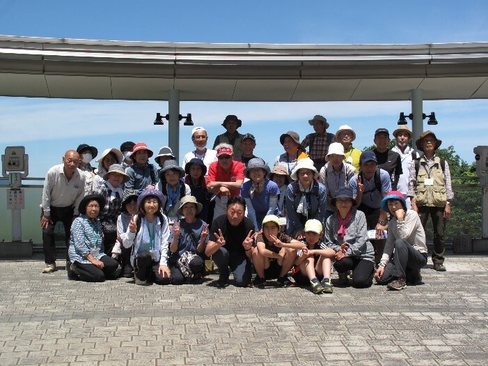 参加者たちがコンクリートの地面の上で集合している写真