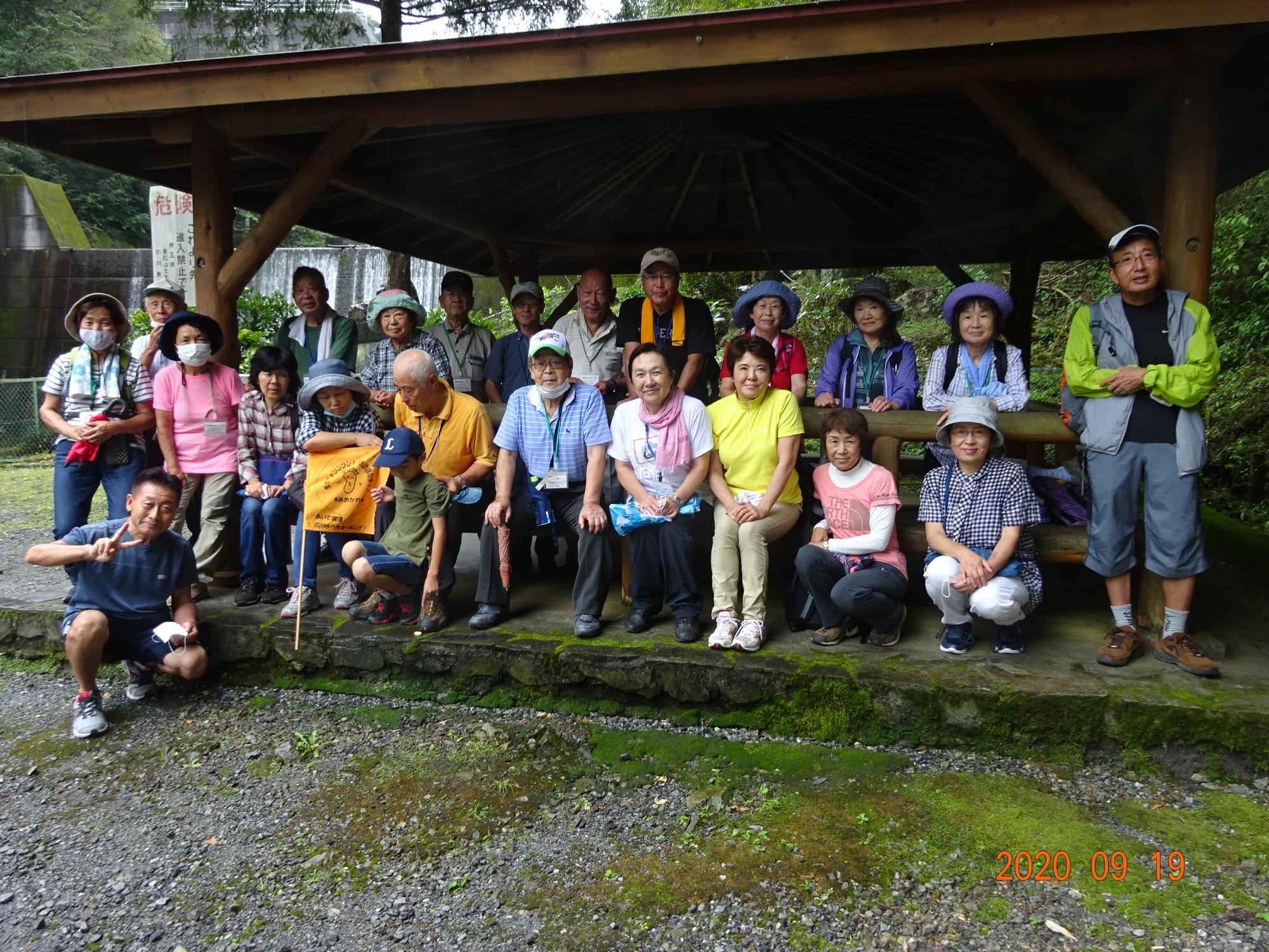 館川ダムの東屋で2列に並んだ二十数名の参加者の方々の集合写真