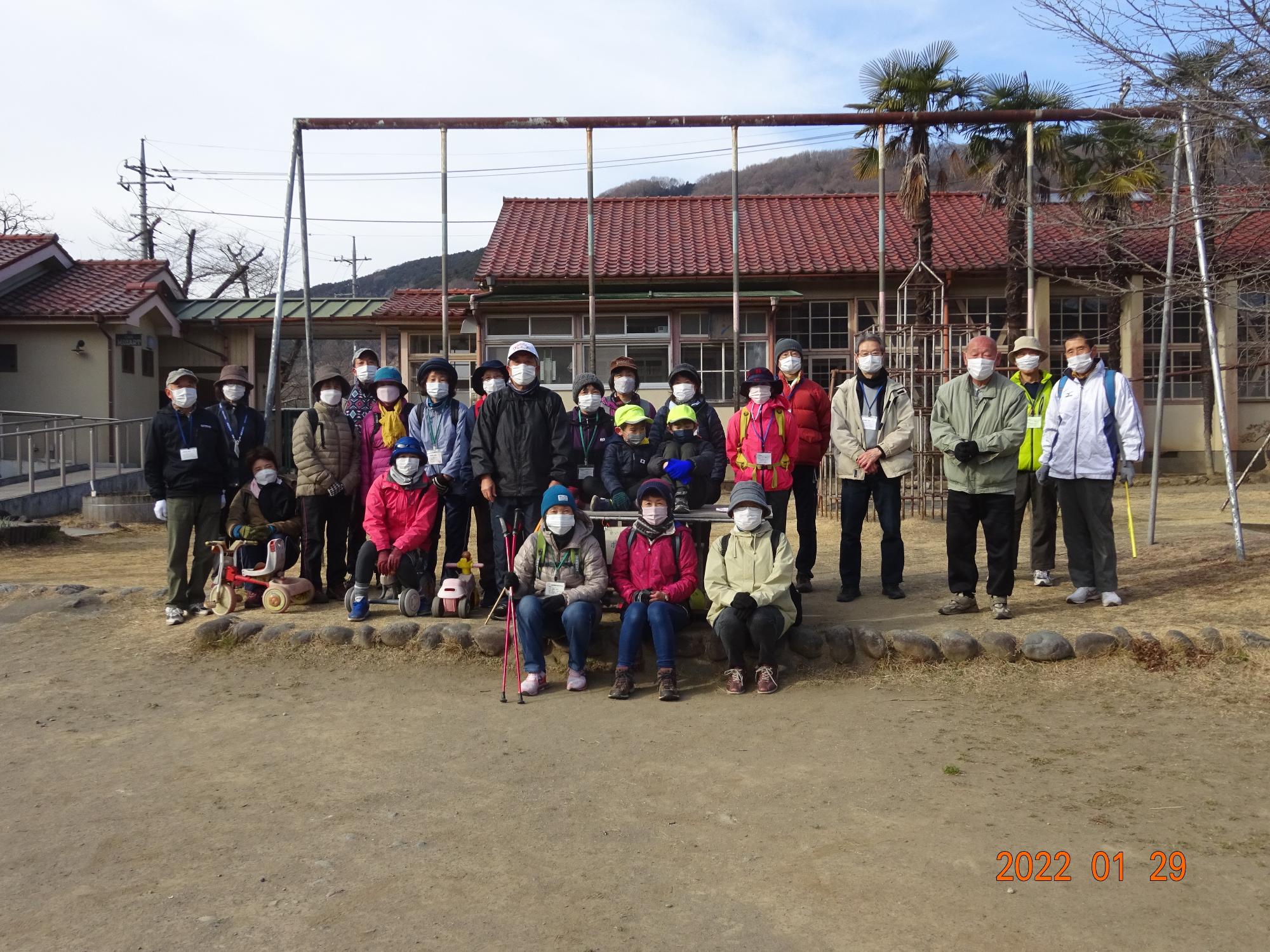 参加者たちが下里分校の敷地内で横並びに並んでいる集合写真