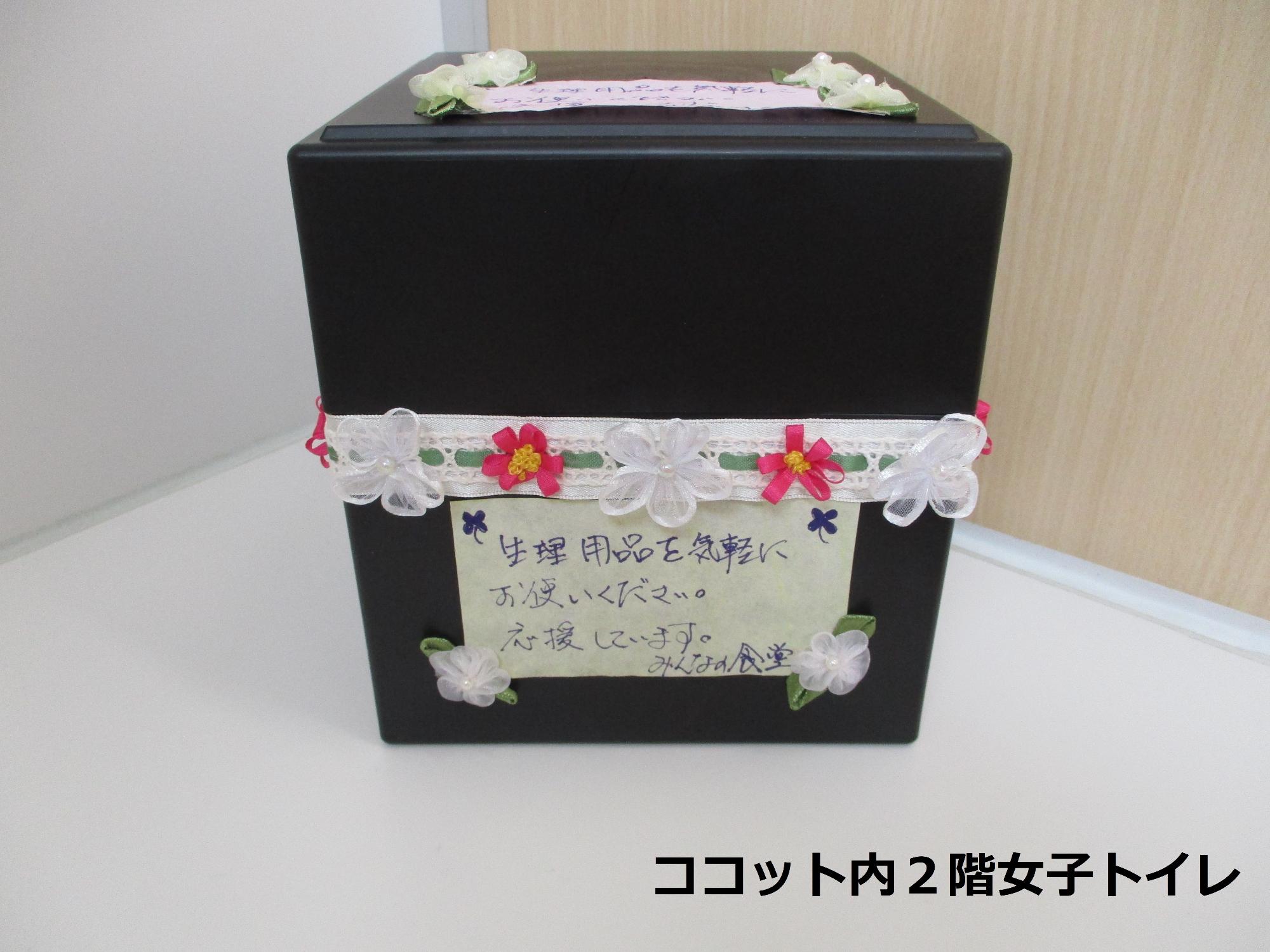 花の飾りがいくつもつけられた蓋つきの四角い箱の写真